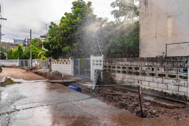 Zavallı sokak İnşaat ve düzeltme zemin Bodrum sonra boru hattından sızdıran musluk suyu Çeşmesi görüntüsünü.