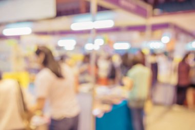 Abstract blur image of people walking in shopping hall or tradeshow with bokeh for background usage.(vintage tone)