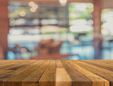 Arkaplan kullanımı için ahşap masa ve bulanık restoran yüzeyine seçici odaklı ton görüntüsü.