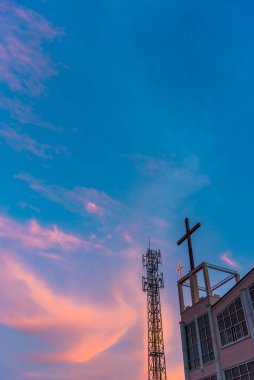 image of of radio tower and red cross with blue sky background on twilight time.(vertical)