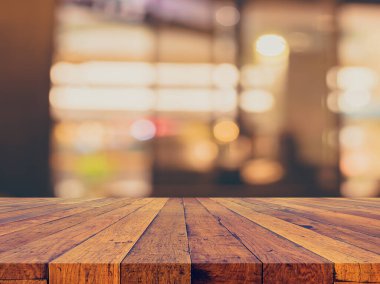 Arkaplan kullanımı için ahşap masa ve bulanık restoran yüzeyine seçici odaklı ton görüntüsü.