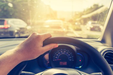 Arka plan kullanımı için gündüz vakti araba kullanan insanların klasik ton görüntüsü. (içeriden fotoğraf çek sürücü eline odaklan)