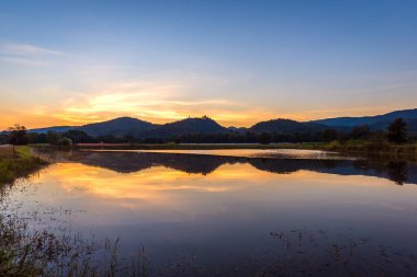 Siluet, alacakaranlık saatinde arka planda dağ ve günbatımı görüntüsü..