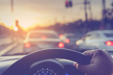 Arka plan kullanımı için gündüz vakti araba kullanan insanların klasik ton görüntüsü. (içeriden fotoğraf çek sürücü eline odaklan)