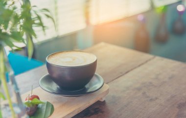 Ahşap masa üzerinde kahverengi Kupası Kahve sanat latte Vintage sesi görüntü.