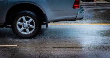 Araba sürüşünün klasik ton görüntüsü sağanak yağmurdan sonra caddede sel baskını yapan suyu geçiyor.