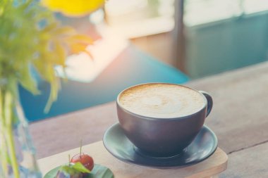 Ahşap masa üzerinde kahverengi Kupası Kahve sanat latte Vintage sesi görüntü.