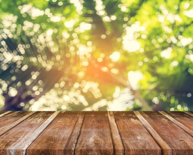 Arkaplan kullanımı için ahşap tablo ve yeşil ağaç bokeh 'in soyut bulanık resmi .