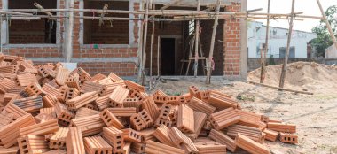 vintage tone image of building under construction and bricks on day time with copy space for background usage.