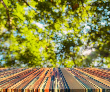 Ahşap tablo ve arkaplan kullanımı için güneşi olan soyut yeşil ağaç Bokeh 'in bulanık görüntüsü.