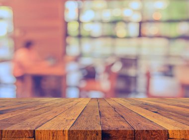 Arkaplan kullanımı için ahşap masa ve bulanık restoran yüzeyine seçici odaklı ton görüntüsü.