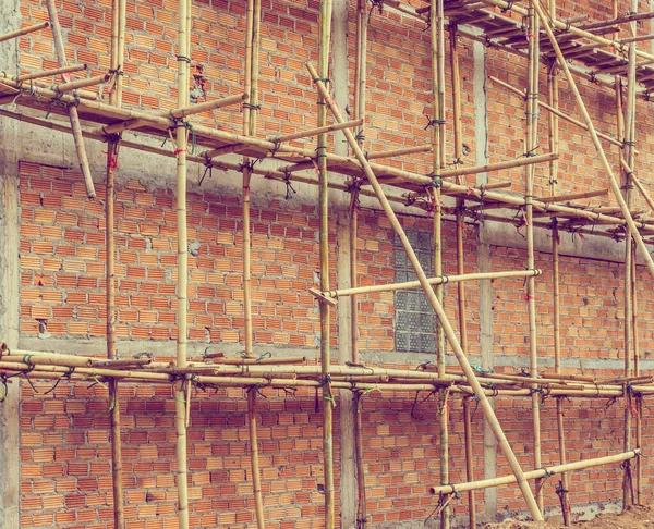 vintage tone image of building under construction and bricks on day time.