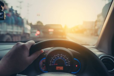 Arka plan kullanımı için gündüz vakti araba kullanan insanların klasik ton görüntüsü. (içeriden fotoğraf çek sürücü eline odaklan)