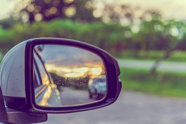 Gün batımında arka planda perspektif yolunu görmek için kanat aynası görüntüsü.