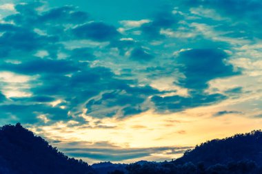 Arka planda dağ ve günbatımı görüntüsü var. (Klasik ton))