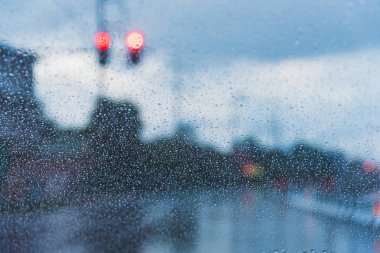 Arka planda bulanık sokak bokeh ile Bardaktaki Yağmur Damlaları