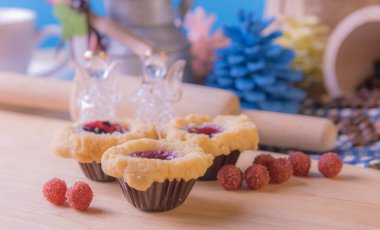 Ahşap masanın üzerinde arkaplanda çeşitli dekorasyonlarla yabanmersini Crumb Cake resmi.