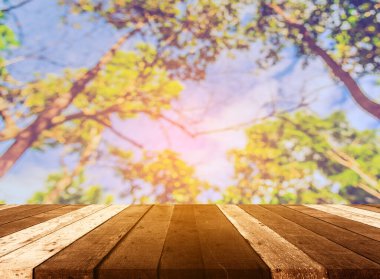 Arkaplan kullanımı için ahşap tablo ve yeşil ağaç bokeh 'in soyut bulanık resmi .