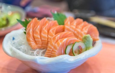 Tabakta dilimlenmiş çiğ ve taze somon balığı resmi..