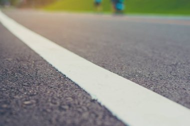 Mavi yeşil bahçeyi görmek için gündüz vakti asfalt yola bakan klasik ton görüntüsü. (sokak dokusuna odaklan)