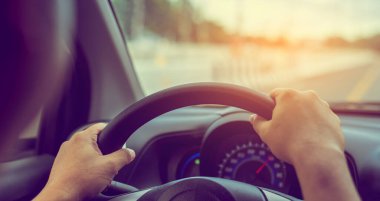 Arka plan kullanımı için gündüz vakti araba kullanan insanların klasik ton görüntüsü. (içeriden fotoğraf çek sürücü eline odaklan)