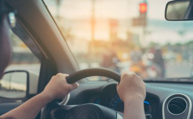 Arka plan kullanımı için gündüz vakti araba kullanan insanların klasik ton görüntüsü. (içeriden fotoğraf çek sürücü eline odaklan)