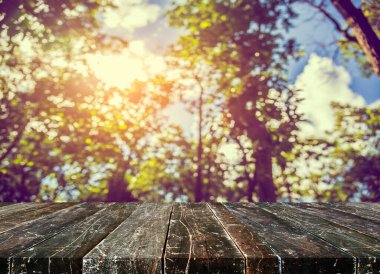 Arkaplan kullanımı için ahşap tablo ve yeşil ağaç bokeh 'in soyut bulanık resmi .