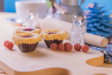 Ahşap masanın üzerinde arkaplanda çeşitli dekorasyonlarla yabanmersini Crumb Cake resmi.