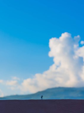 Minyatür bebek fikri fotoğrafçı görüntüsü. Güzel dağ ve mavi gökyüzü. Gün içinde arka planda..