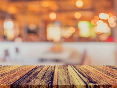 Ahşap masa ve kahve dükkanının geçmişi bulanık ve Bokeh görüntüsü var. (Klasik ton))