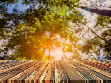 Arkaplan kullanımı için ahşap tablo ve yeşil ağaç bokeh 'in soyut bulanık resmi .