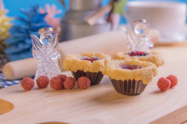 Ahşap masanın üzerinde arkaplanda çeşitli dekorasyonlarla yabanmersini Crumb Cake resmi.
