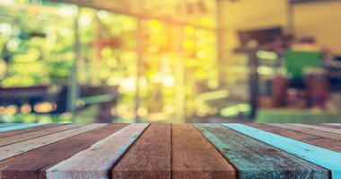 Boş ahşap masa ve klasik ton kahve dükkanının arka planını bulanıklaştırdı .