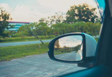 Günbatımında arka planda perspektif yolunu görmek için kanat aynasının klasik ton görüntüsü