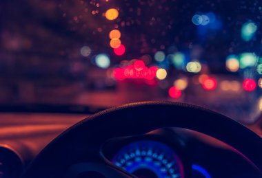 Arka plan kullanımı için gece vakti araba kullanan insanların klasik ton görüntüsü. (içeriden fotoğraf çek)