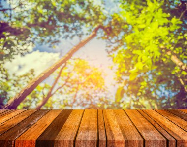 Arkaplan kullanımı için ahşap tablo ve yeşil ağaç bokeh 'in soyut bulanık resmi .