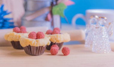 Ahşap masanın üzerinde arkaplanda çeşitli dekorasyonlarla yabanmersini Crumb Cake resmi.