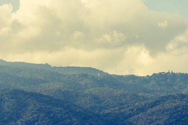 Tropikal yeşil dağ ormanlarının ve bulutlu gökyüzünün günlük görüntüsü..