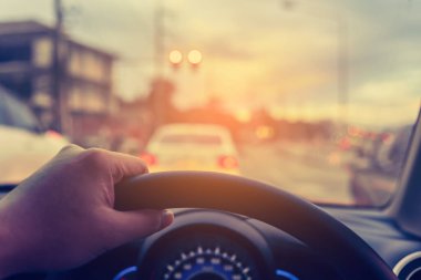 Arka plan kullanımı için gündüz vakti araba kullanan insanların klasik ton görüntüsü. (içeriden fotoğraf çek sürücü eline odaklan)