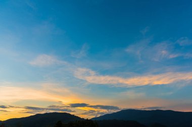 Arkaplanda dağ ve günbatımı görüntüsü.