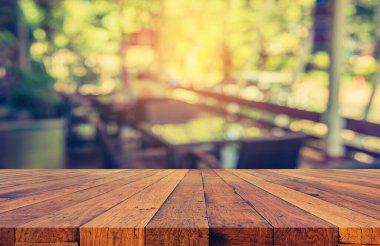 Boş ahşap masa ve klasik ton kahve dükkanının arka planını bulanıklaştırdı .