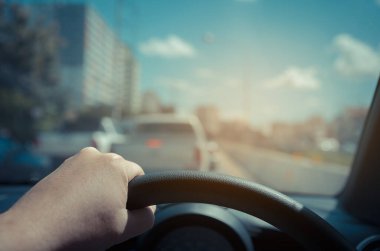 Arka plan kullanımı için gündüz vakti araba kullanan insanların klasik ton görüntüsü. (içeriden fotoğraf çek sürücü eline odaklan)