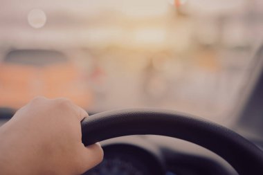 Arka plan kullanımı için gündüz vakti araba kullanan insanların klasik ton görüntüsü. (içeriden fotoğraf çek sürücü eline odaklan)