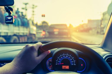 Arka plan kullanımı için gündüz vakti araba kullanan insanların klasik ton görüntüsü. (içeriden fotoğraf çek sürücü eline odaklan)