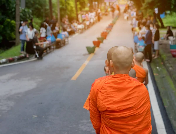 朝通りを歩く僧侶の姿を人々は食べ物を提供するのを待っています — ストック写真