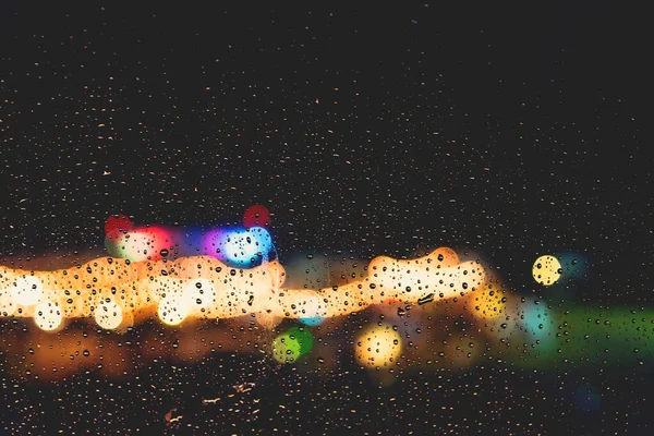 玻璃杯上的雨滴 背景上有模糊的街道凹凸不平 复古音 — 图库照片