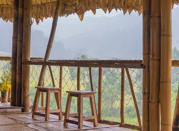 雨の日に竹の小屋の椅子が熟した田んぼを見るイメージ — ストック写真
