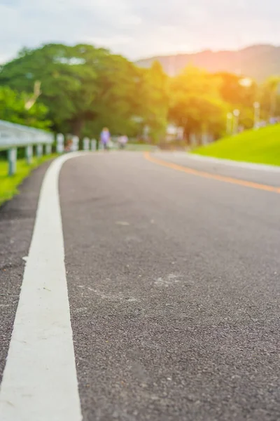 青い緑の庭を見るために昼間のパースペクティブアスファルト道路の垂直ヴィンテージトーン画像 ストリートテクスチャに焦点を当て — ストック写真