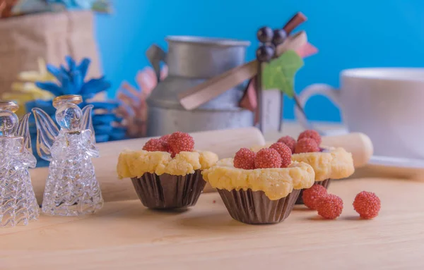 Ahşap masanın üzerinde arkaplanda çeşitli dekorasyonlarla yabanmersini Crumb Cake resmi.