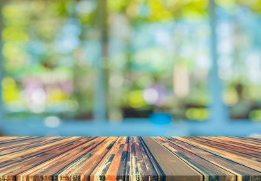 Boş ahşap masa ve bulanık oturma odası arka planı.